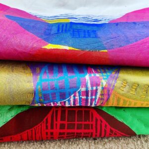 Folded pile of colourful textile art work