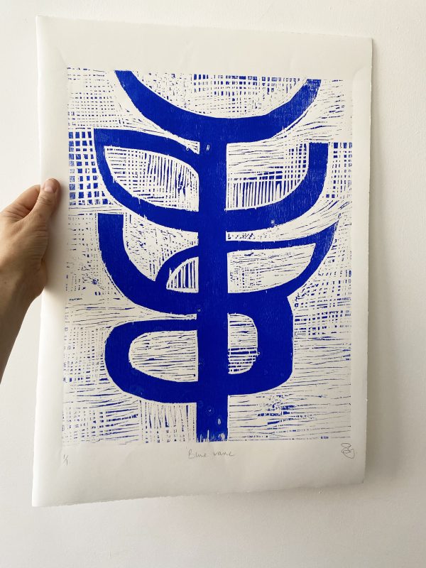 woodcut print in ultramarine blue held up with hand