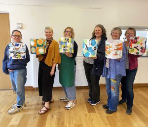 Group of ladies holding up their printed lampshades at Worrall Hall
