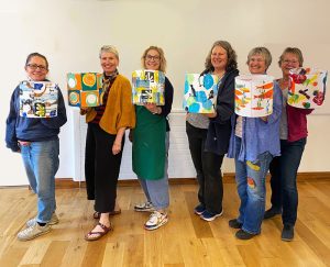 ladies smiling and holding up their lampshades worrall hall