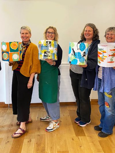 ladies smiling and holding up their lampshades worrall hall