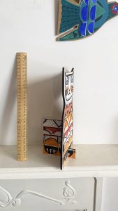 Ginger cat side view with ruler and decorative birds