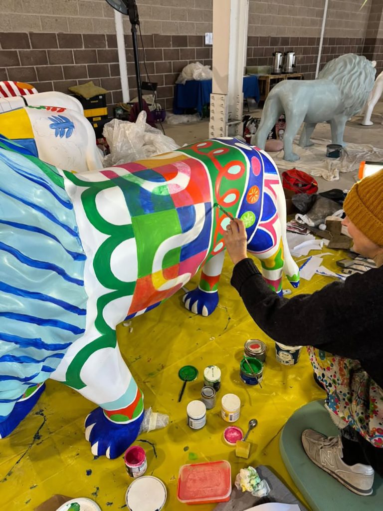 sam painting a lion sculpture