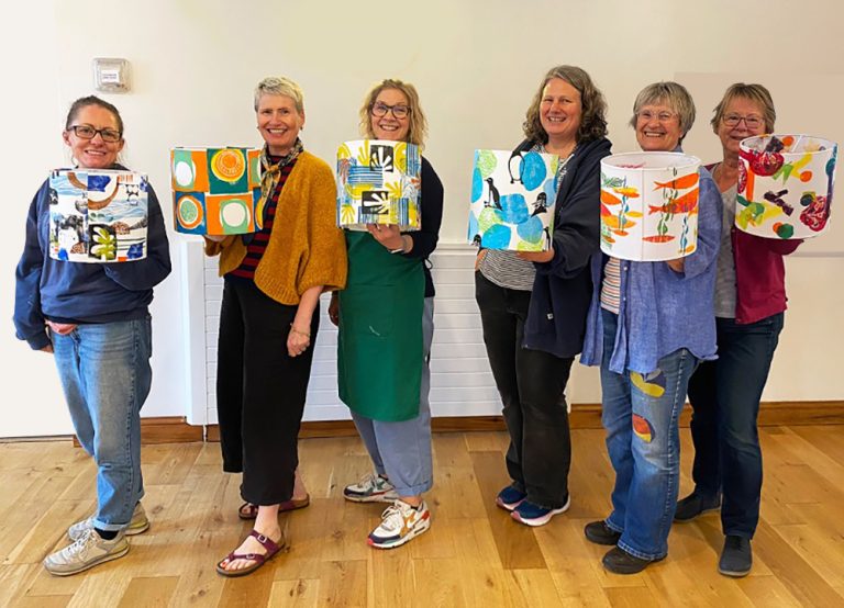 6 ladies smiling and holding up their lampshades worrall hall